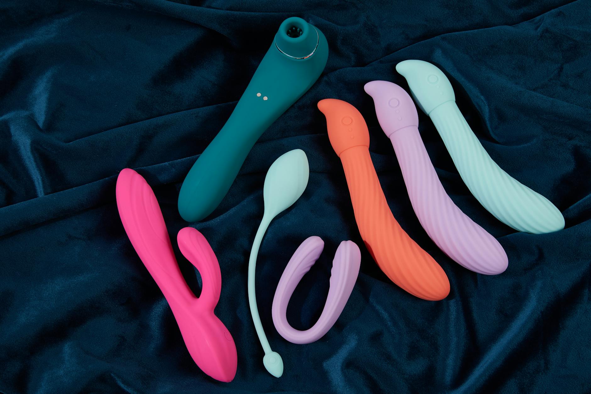 Blue silicone lemon vibrator held gently in hand against a purple background