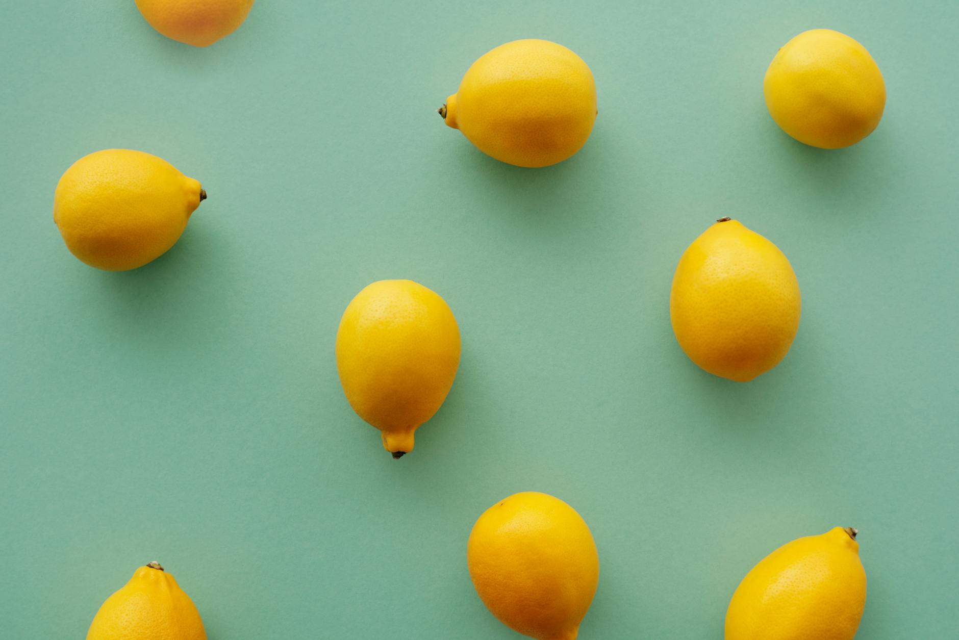 Bright yellow lemons arranged on a pastel green background, symbolizing freshness and gentle recovery