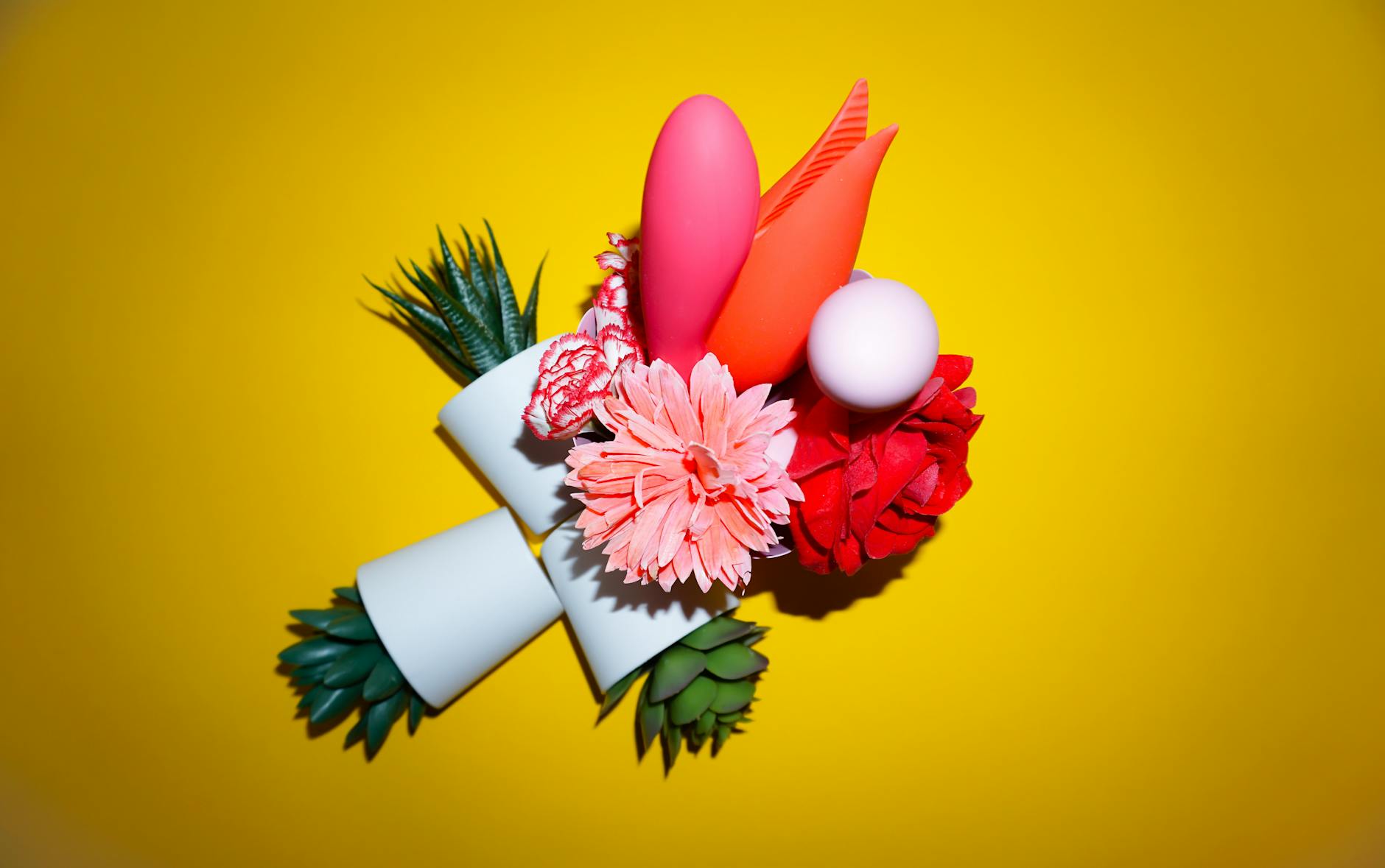 Hand holding an orange vibrator against a minimalistic purple backdrop